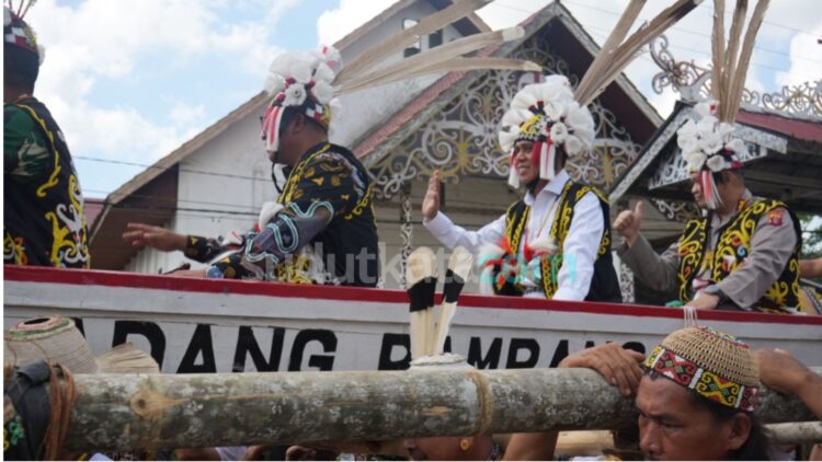 Ketua DPRD Kota Samarinda Helmi Abdullah melambaikan tangan kepada masyarakat saat mengikuti prosesi penyambutan adat pada pembukaan Festival Budaya Dayak Kenyah 2026 di Desa Budaya Pampang, Samarinda, Kamis (25/6/2026). Dalam tradisi Dayak Kenyah, para tamu kehormatan diarak dan dipikul sebagai simbol penghormatan, kebersamaan, serta penerimaan masyarakat adat terhadap para pemimpin yang hadir.