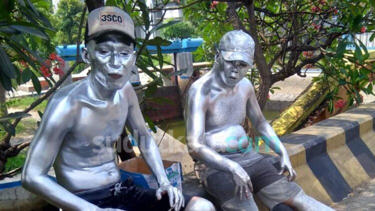 Dua manusia silver duduk di salah satu area ruang publik. Keduanya mengenakan pakaian kasual dan tubuh serta wajah dicat dengan warna perak. Fenomena manusia silver yang beraktivitas di ruang publik dan persimpangan jalan menjadi sorotan DPRD Samarinda. (Ist)