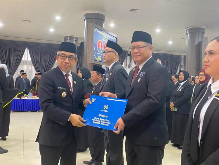Bupati Kutai Timur (Kutim) Ardiansyah Sulaiman saat menyerahkan Tanda Kehormatan Satyalencana Karyasatya kepada 512 Aparatur Sipil Negara (ASN)